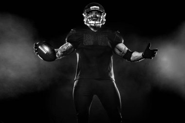 Kopya alanı siyah zemin üzerine Amerikan futbolu oyuncusu