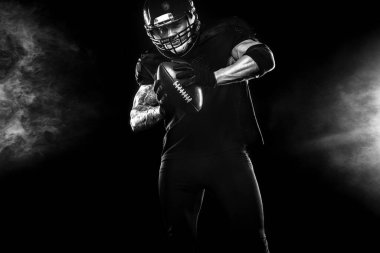 Kopya alanı siyah zemin üzerine Amerikan futbolu oyuncusu