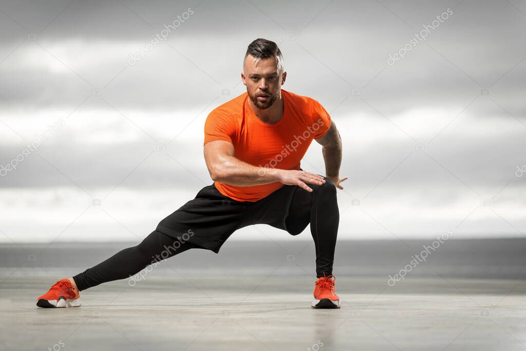 Athletic man doing sports exercises on the ocean.