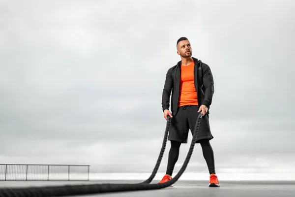 Sportlicher Mann Mit Einem Kampfseil Bei Sportübungen Auf Dem Meer — Stockfoto