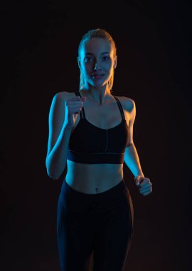 Woman Atlete Runner. Sprinter Run. Athletic Woman Running on Black Background. Fitness and Sport Motivation