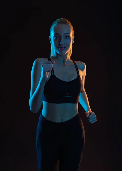 Woman Atlete Runner. Sprinter Run. Athletic Woman Running on Black Background. Fitness and Sport Motivation