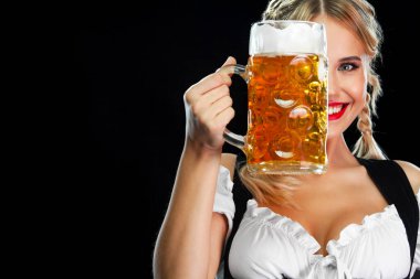 Geleneksel bir Bavyera ya da Alman dirndl giyip, siyah arka planda içkili büyük bira bardakları servis eden genç seksi Ekim Festivali kız garsonu.
