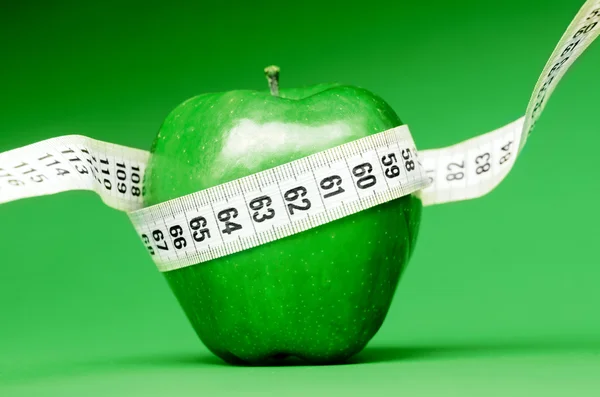 Delicious apple with measuring tape — Stock Photo, Image