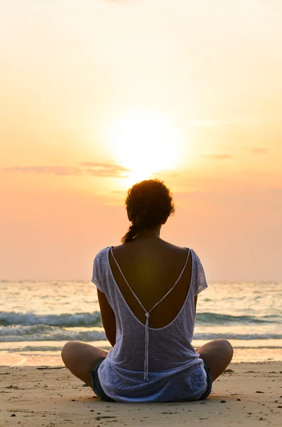 Zittend op het strand bij zonsopgang — Stockfoto