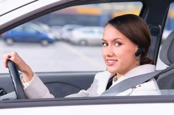 Konuşmak bir arabada bir kulaklık kullanarak telefon — Stok fotoğraf