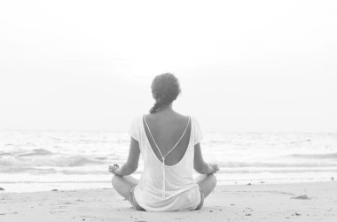 kumsalda güneş doğarken oturan