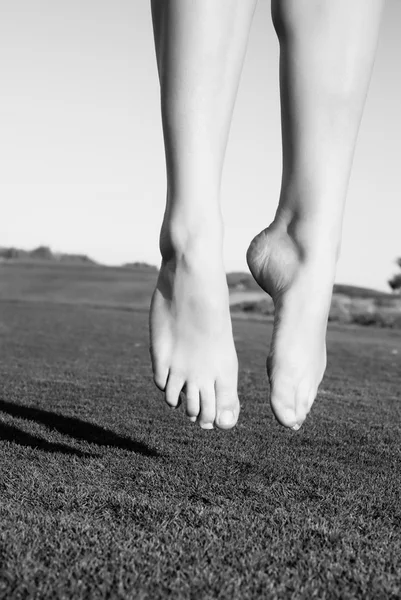 Pieds de saut sur vert champ femme — Photo