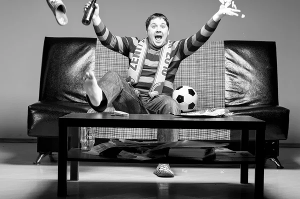 Футбольний вентилятор на дивані — стокове фото