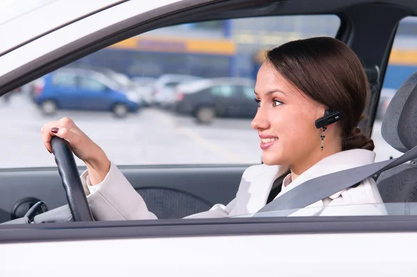 Talking phone in a car using a headset — Stock Photo, Image