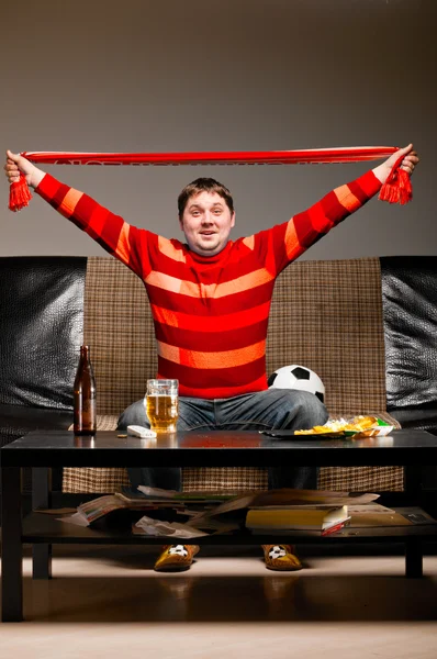 Soccer fan on sofa — Stock Photo, Image