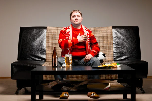 Soccer fan on sofa — Stock Photo, Image