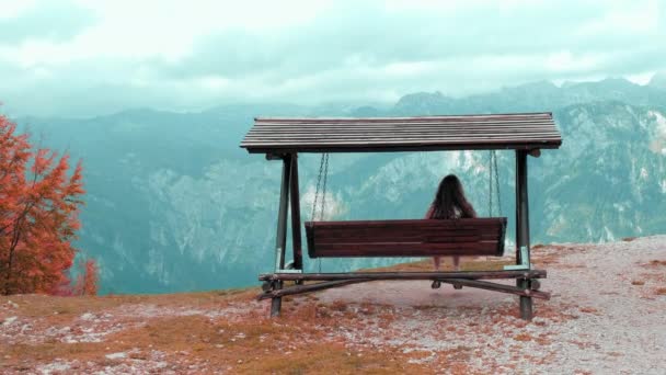 Žena houpající se v alpské vesnici s výhledem na hory — Stock video