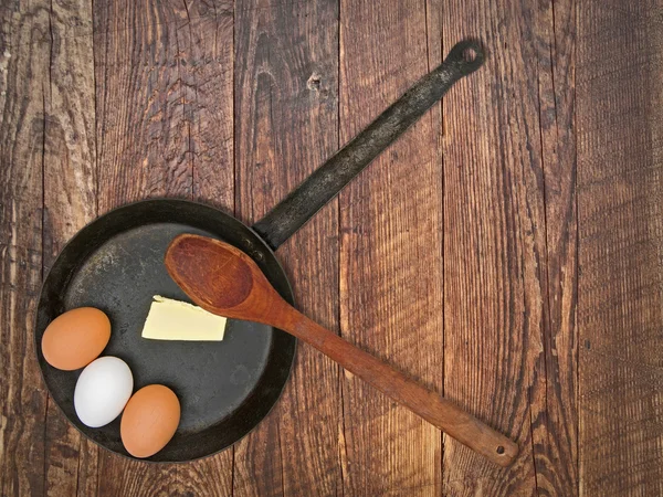 Vintage set for frying eggs over wooden table — Stock Photo, Image