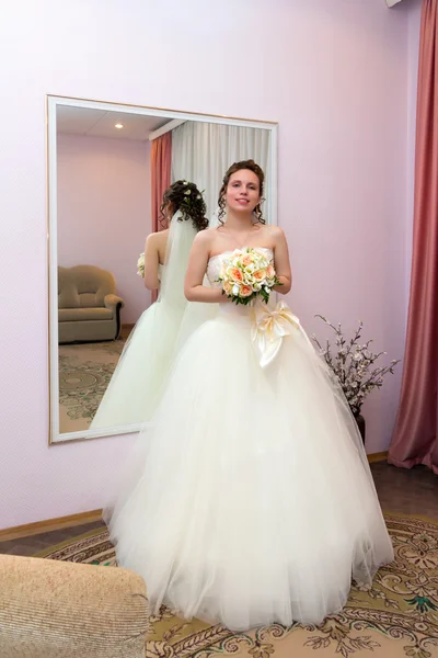 A noiva com um buquê de flores no fundo do espelho — Fotografia de Stock