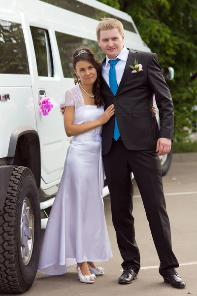 Portrait of bride and groom near limousine — Stock Photo, Image