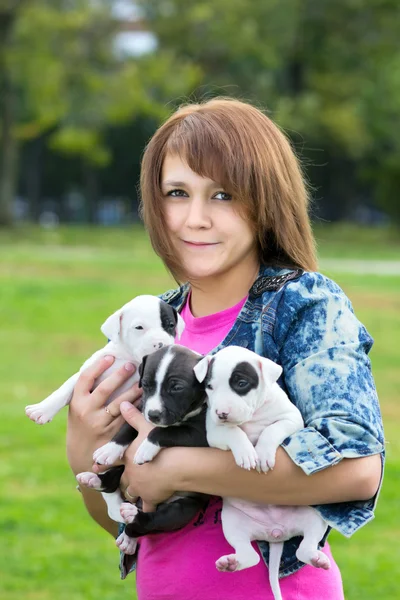 Giovani donne che tengono tre cuccioli — Foto Stock
