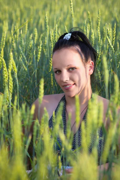 Vacker flicka på ett vetefält — Stockfoto