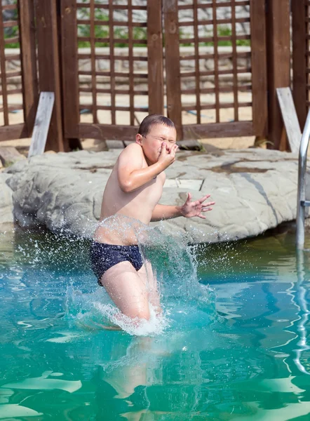 Rapaz salta para a piscina — Fotografia de Stock