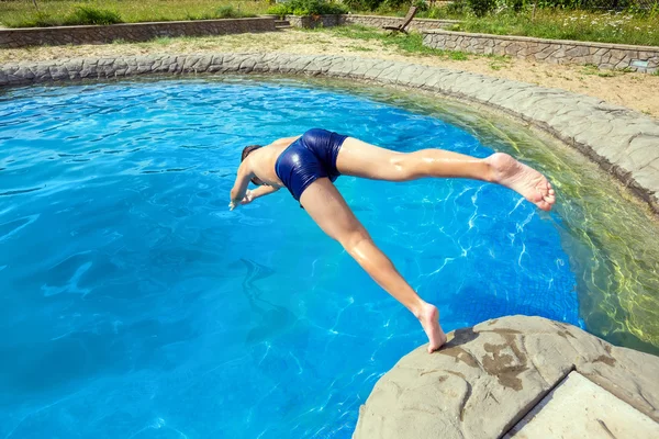Teenager jumping into pool — Stock Photo, Image