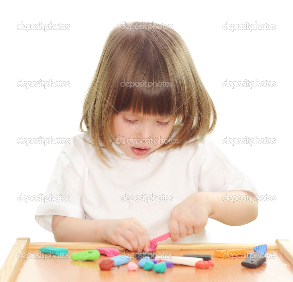 Little girl playing with clay.