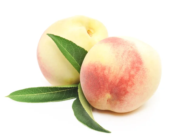 Ripe peach fruits with green leaves — Stock Photo, Image