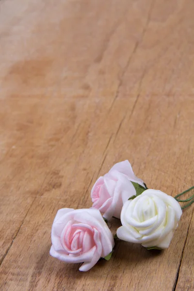 Flores artificiales en el tablero de madera — Foto de Stock