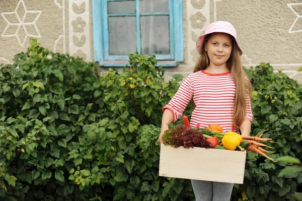 Mädchen mit einer Kiste Gemüse — Stockfoto