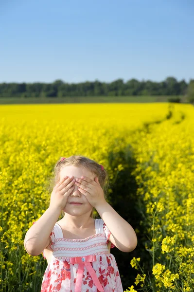 Liten flicka på gult fält — Stockfoto