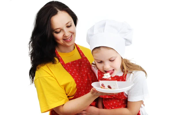 Mother holding a plate with cake hugging her daughter — Stock Photo, Image