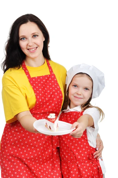 Madre in possesso di un piatto con torta abbracciando sua figlia — Foto Stock