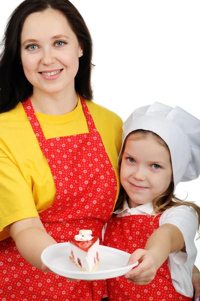 Madre in possesso di un piatto con torta abbracciando sua figlia — Foto Stock