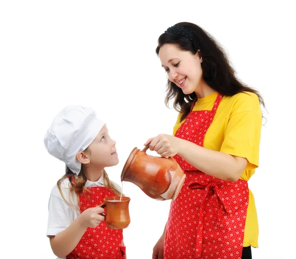 Mother pouring milk in mug for daughter — Stock Photo, Image