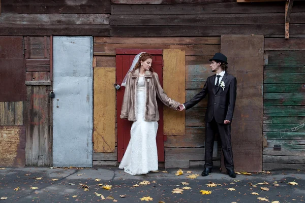 Bride and a groom standing near the building — Stock Photo, Image