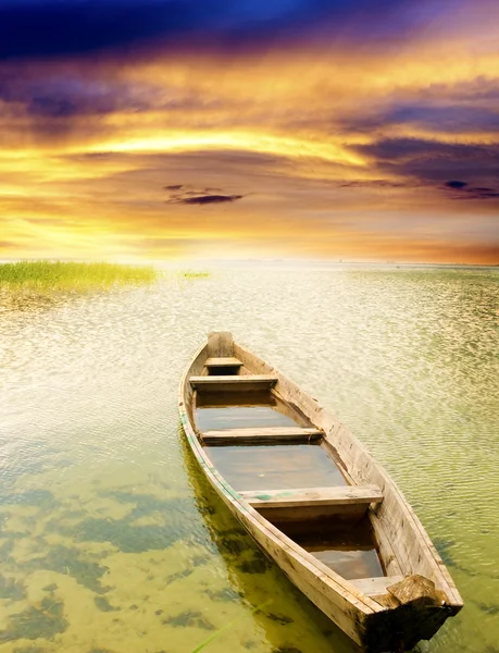 Lodí na pobřeží proti západu slunce. — Stock fotografie