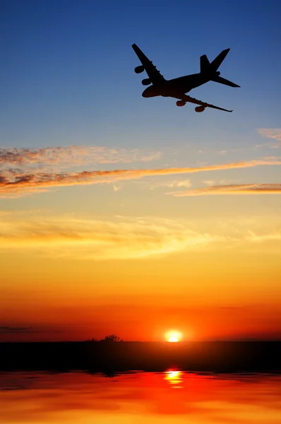 Silhueta de avião voar sobre a água — Fotografia de Stock