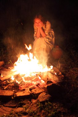 kız çocuk oturma ve ateşe bakarak vintage elbise