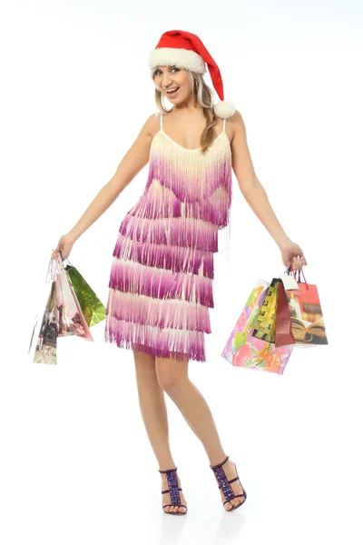 The girl in the hat of Santa Claus holding a variety of packages — Stock Photo, Image