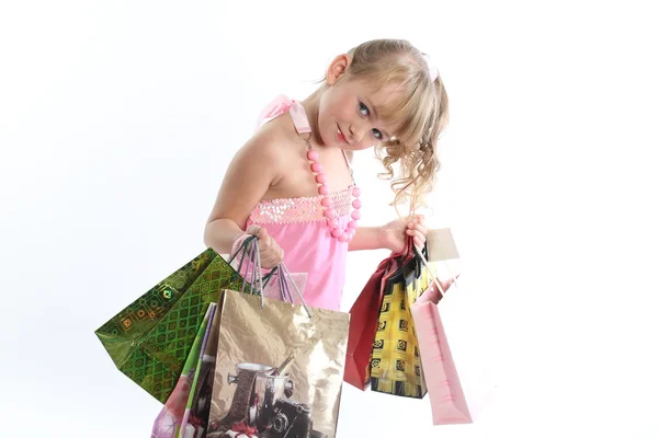 Menina do bebê mostra uma variedade de pacotes com presente — Fotografia de Stock