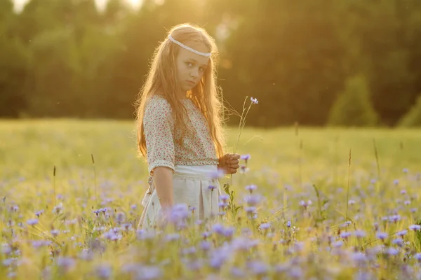 Baby girl in a long dress in the middle of the field laughing — Stock Photo, Image