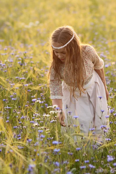 Baby girl in a long dress in the middle of the field laughing — Stock Photo, Image