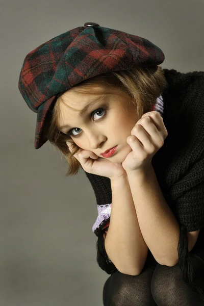 Menina adolescente com grandes pestanas e um chapéu com uma viseira — Fotografia de Stock