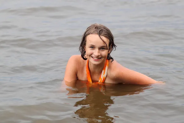 Piękna dziewczynka emocjonalność w sukni pływa w wodzie — Zdjęcie stockowe