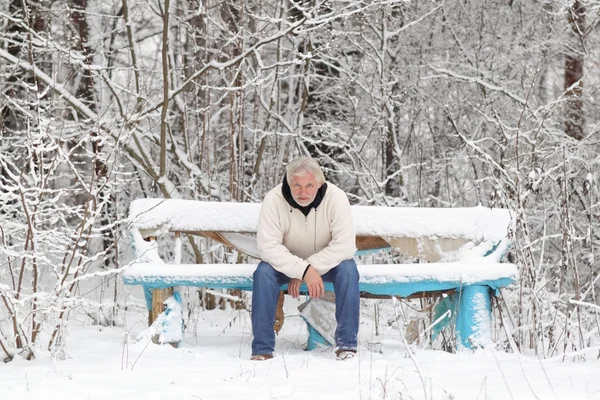 Un atractivo hombre gris de mediana edad sentado en el banco — Foto de Stock