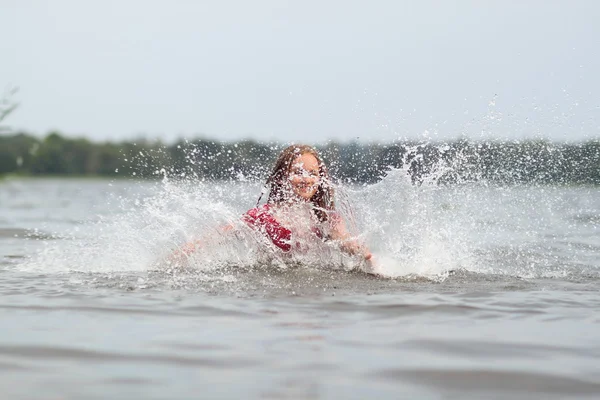 Beautiful emotional girl child in dress swims in the water — Stock Photo, Image