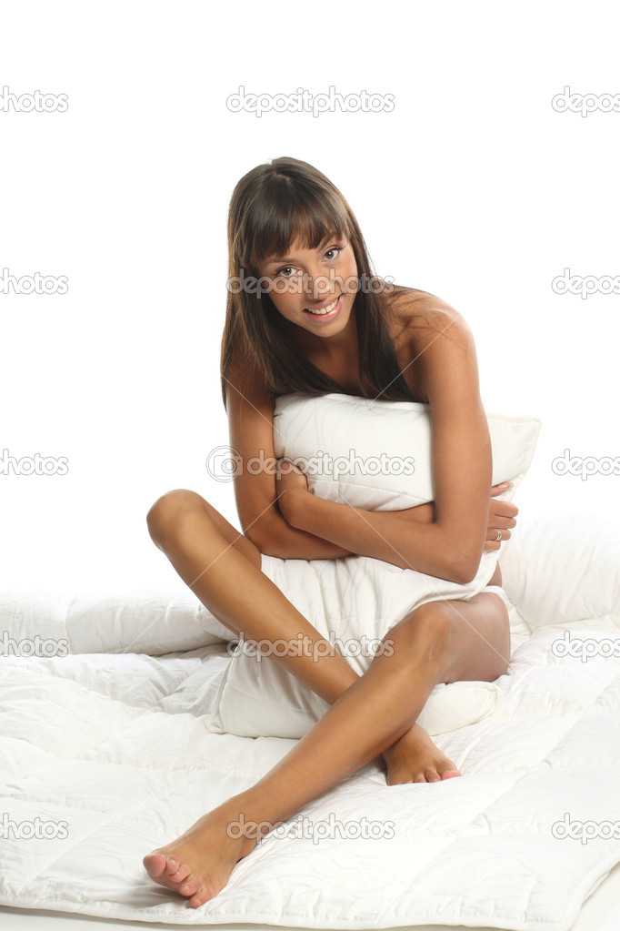 Nude attractive girl sitting on bed and hugging pillow