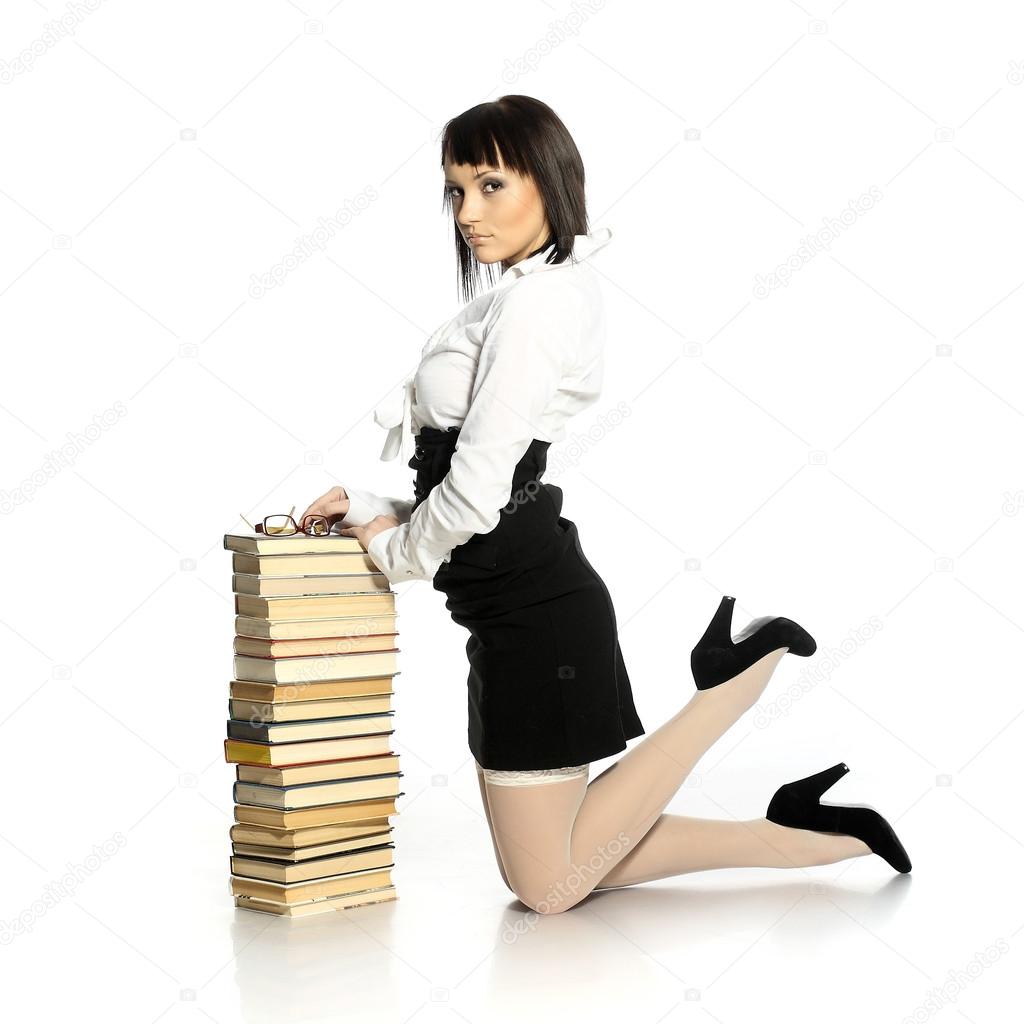 Attractive girl dressed in erotic stockings leaning on a stack of books