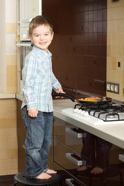 Mały chłopiec gotowanie w pobliżu pieca gazowego — Zdjęcie stockowe