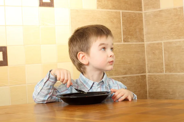 Маленький мальчик ест за столом — стоковое фото