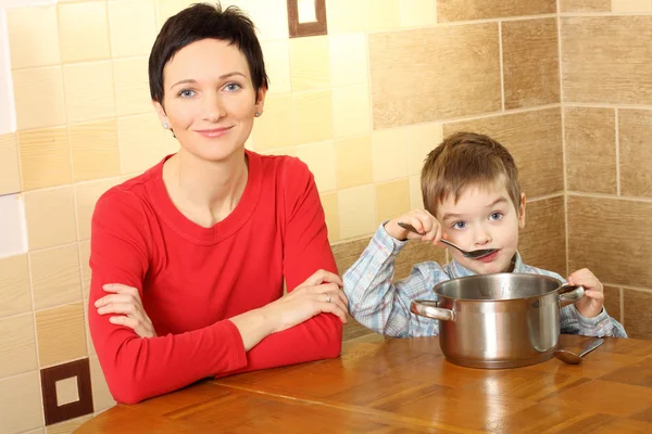 Maminka s stravovací synem v kuchyni — Stock fotografie